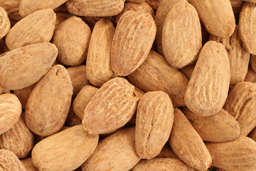 Food background - big shelled roasted salted almonds situated arbitrarily