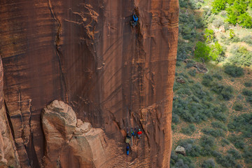 Climbers scaling sandstone wall in Zion National Park
