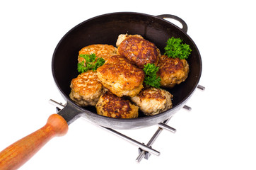 Frying pan with fried cutlets on white background