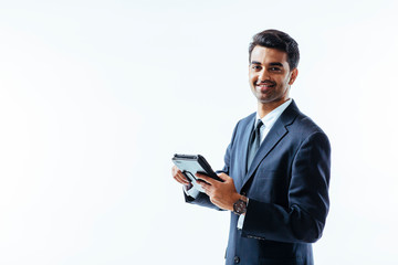 Portrait of man in business suit holding electronic tablet pad and smiling at camera, isolated on white background. © Carlos David