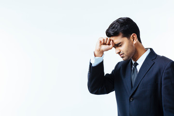 Portrait of a handsome businessman holding his head in disbelief, in pain or meditating,  isolated on white background.