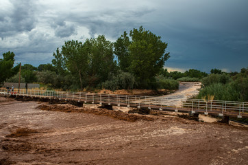 Flash flood running running over road in rural desert town