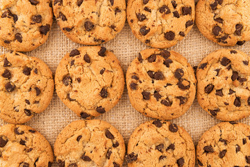 Flat lay of homemade chocolate chip cookies on burlap background. Close up.