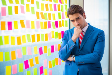 Young handsome employee with many conflicting priorities   