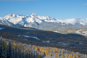 Mountain and forest with fall foliage and snow