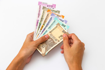 Female hands holding brand new 10, 50, 100, 200, 500 and 2000 indian rupees banknotes.