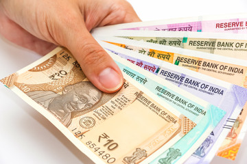 Female hands holding brand new 10, 50, 100, 200, 500 and 2000 indian rupees banknotes.