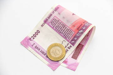 Close up view of brand new indian 2000 rupees banknote and 10 rupees coin.