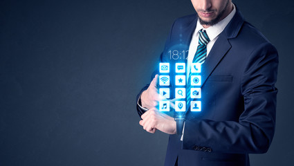 Businessman wearing smartwatch with application icons.