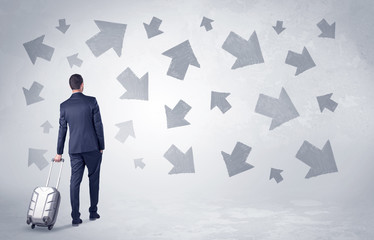Obraz premium Businessman with back walking away with higgledy-piggledy arrows around 