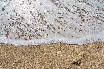 White foam on a sandy beach. Copy space.