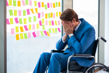 Young handsome man in wheelchair with many conflicting prioritie