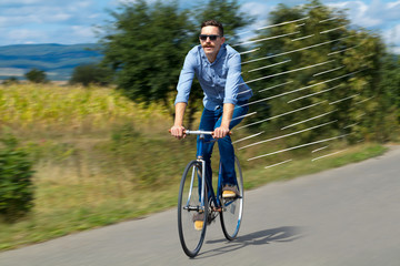Obraz premium Casual hipster cyclist riding bicycle with high speed concept