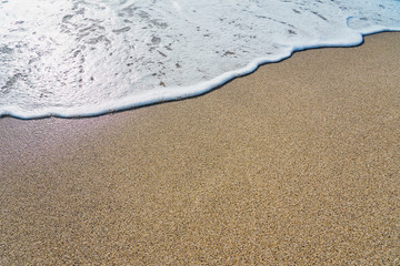  White foam on a sandy beach. Copy space.