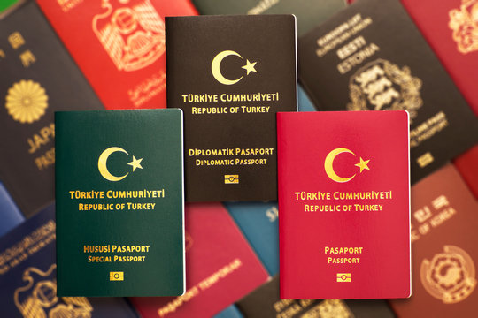 Multicolored different passports of Turkey on a blurred background of various documents of many countries of the world