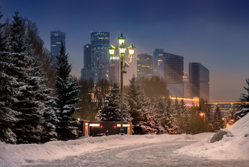 Moscow City International Business Center. Modern skyscrapers in Moscow, tallest buildings in Europe. Night winter urban landscape with snowy road and street light.