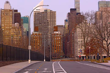 A road to Manhattan skyscrapers in perspective, New York, USA. Early morning on Roosevelt Island in winter.