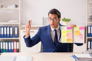 Young handsome employee planning his work activity 