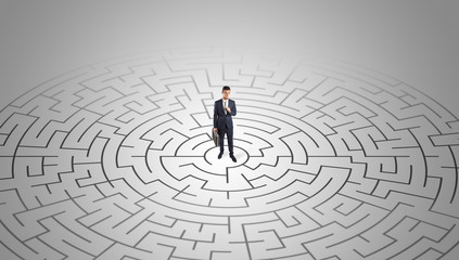 Elegant businessman looking for a solution in a middle of a maze

