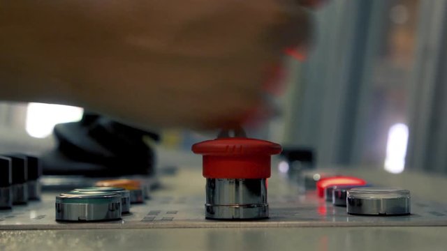 Real machine operation desk with green lamp and red emergency or alarm lamp indicator, engineer 's hand push the emergency and reset button, Industrial and Automation concept.