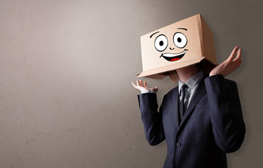 Young boy standing and gesturing with a cardboard box on his head
