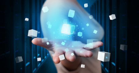 Person holding hologram projection displaying white cubes in server room
