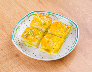 Paneer Burfi or Paneer Kesar Burfi is a Traditional Indian Mithai or Sweet Dish Prepared From Freshly Made Paneer, Mawa, Milk or Cottage Cheese on Wooden Background