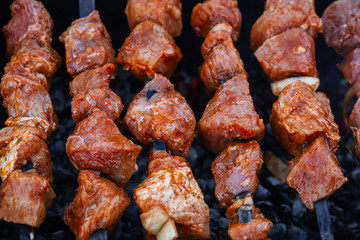 barbecue of pork is prepared on skewers on the grill for a summer picnic