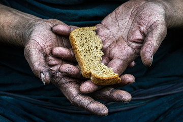 Dirty hands homeless poor man with piece of bread in modern capitalism society