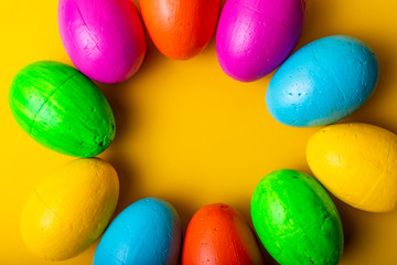 Easter eggs of different colors on a yellow background.