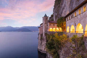 Ancient hermitage at sunset. Picturesque view of Santa Caterina del Sasso (XIII century), one of...