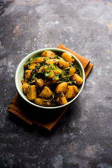 Aloo Palak sabzi - Potato cooked with spinach with added spices. a healthy Indian main course recipe. Served in a bowl, selective focus