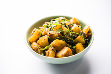 Aloo Palak sabzi - Potato cooked with spinach with added spices. a healthy Indian main course recipe. Served in a bowl, selective focus