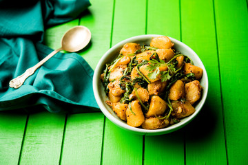 Aloo Palak sabzi - Potato cooked with spinach with added spices. a healthy Indian main course recipe. Served in a bowl, selective focus