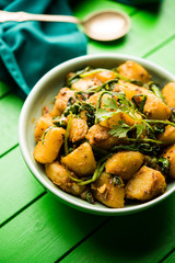 Aloo Palak sabzi - Potato cooked with spinach with added spices. a healthy Indian main course recipe. Served in a bowl, selective focus