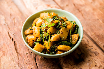 Aloo Palak sabzi - Potato cooked with spinach with added spices. a healthy Indian main course recipe. Served in a bowl, selective focus