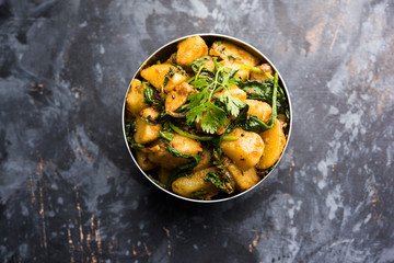 Aloo Palak sabzi - Potato cooked with spinach with added spices. a healthy Indian main course recipe. Served in a bowl, selective focus