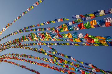 Tibetan Buddhist multicolored prayer flags on the background of a clear blue sky