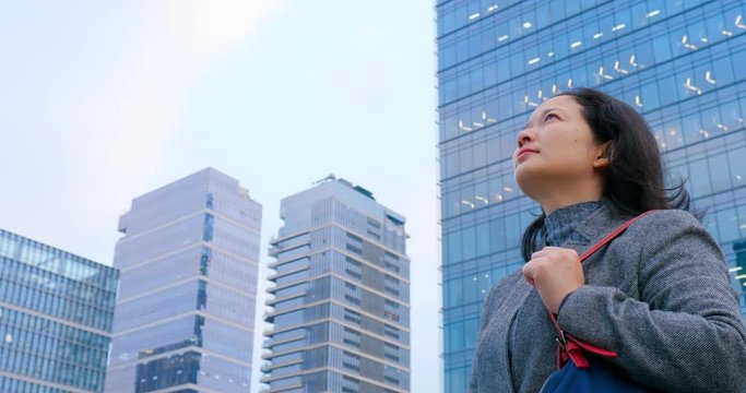 4k:chinese woman looking upward in city,shenzhen china