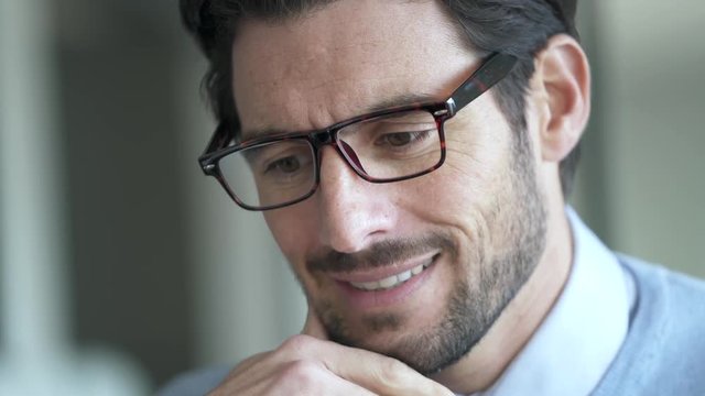 Portrait of attractive man working on laptop wearing glasses