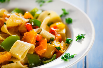 Pasta with vegetables on wooden background