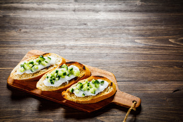 Bruschettas on cutting board on wooden background