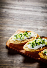 Bruschettas on cutting board on wooden background