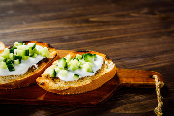 Bruschettas on cutting board on wooden background