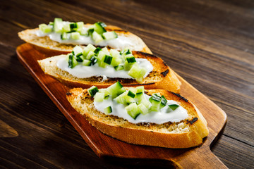 Bruschettas on cutting board on wooden background