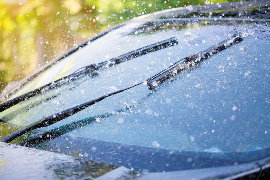 Car windshield with rain drops and frameless wiper blade