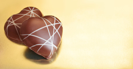 Zwei Lebkuchen in Herz Form liegen auf goldene Platte