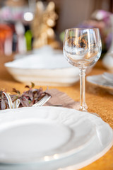 Served table with white plates on a Golden tablecloth