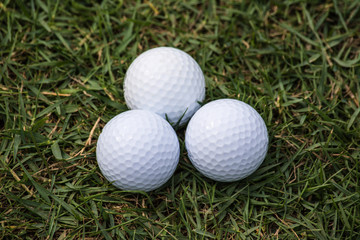 Golf balls are on the grass inside a golf course in Thailand.