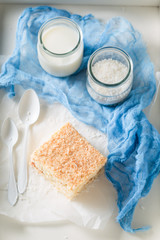 Yummy coconut cake with nuts and foam on white table